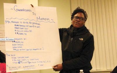 Mattapan Forum: Shavel’le Olivier of Mattapan, held a poster identifying concerns related to displacement and gentrification at a forum held at Mattapan Center for Life last Thursday. 	Caleb Nelson photo